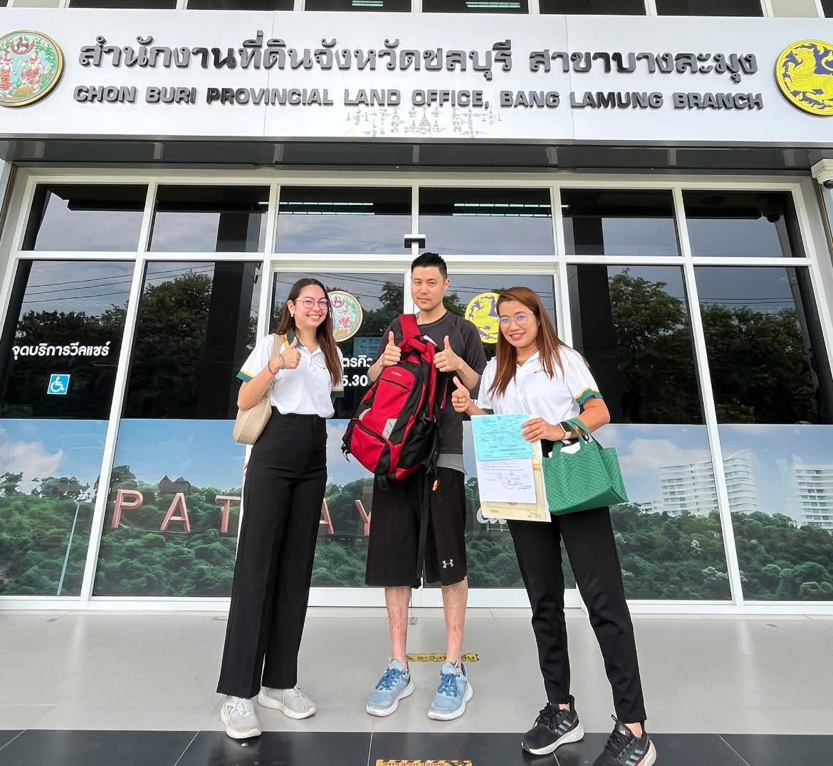 Alan Bolton Property Consultants agent assisting clients at Pattaya Land Office during condo transfer